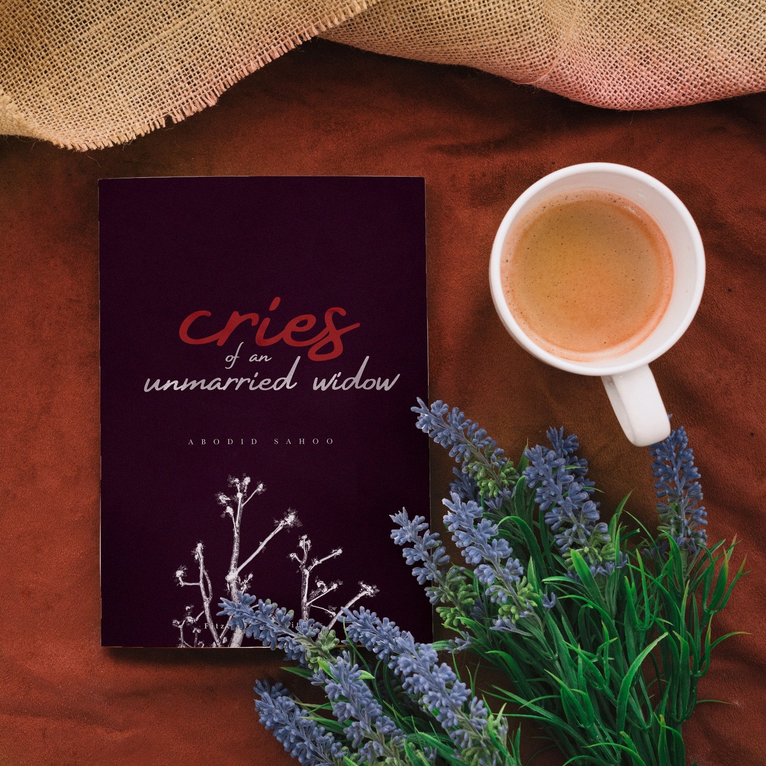 Cries of an Unmarried Widow book beside flowers and a cup